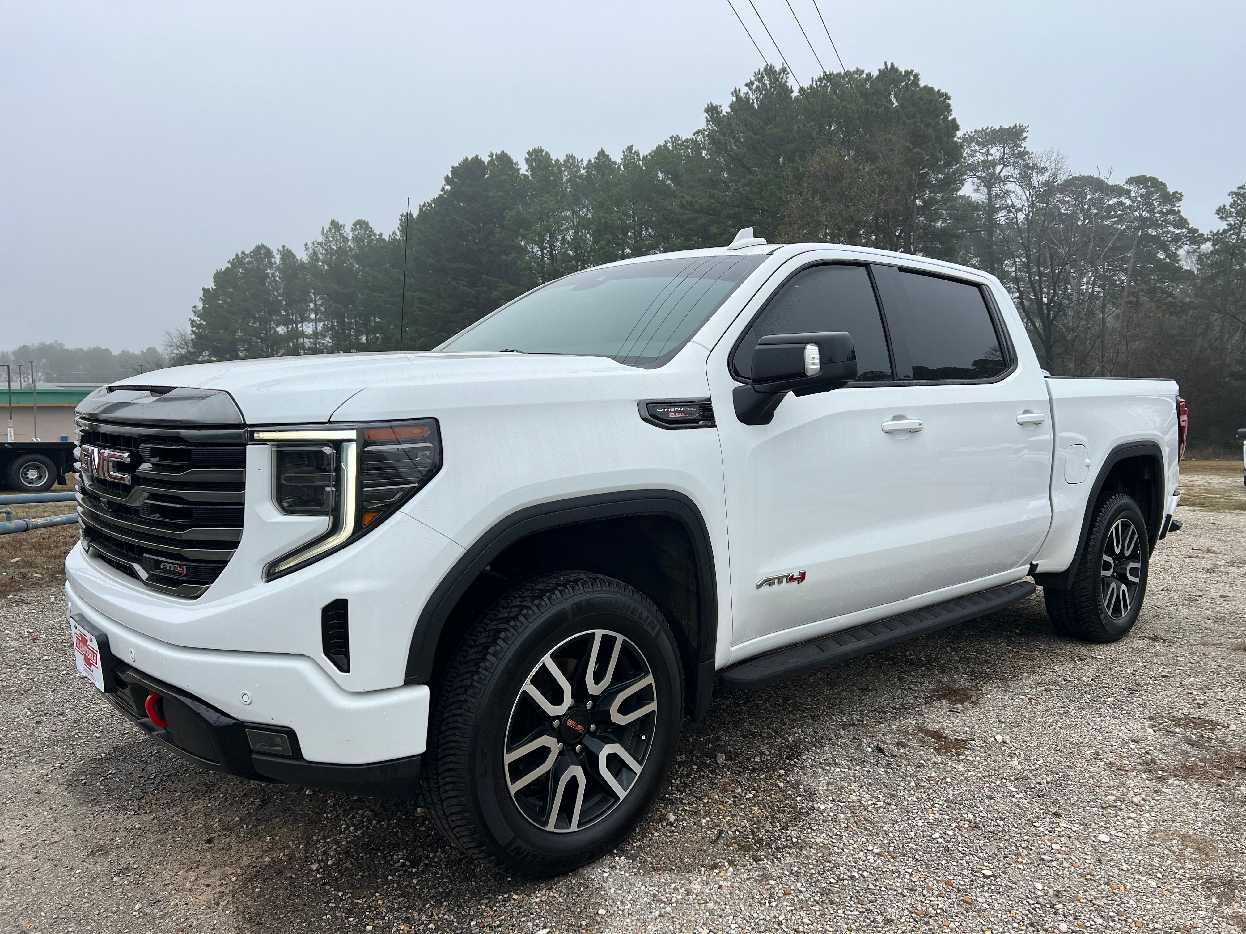 2023 GMC Sierra 1500 AT4 in Summit White — front three-quarter view